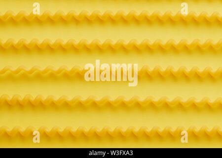 Fusilli lunghi brut pâtes sur fond jaune.jpg Banque D'Images