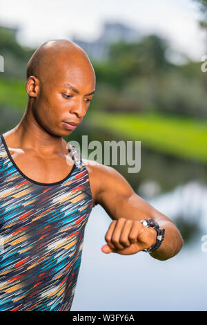 Photo d'un modèle de remise en forme en regardant sa smartwatch avec expression confuse Banque D'Images