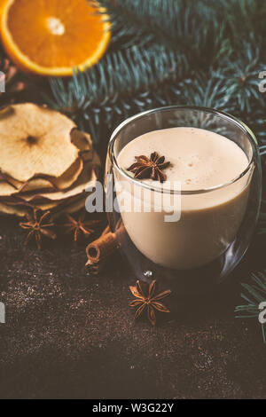 Dans un verre de lait de poule de Noël dans un fond de Noël. Banque D'Images