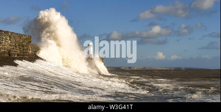 PORTHCAWL, Pays de Galles - Octobre 2018 : Les vagues se briser contre le mur du port dans la lumière du soleil du soir à marée haute à Porthcawl, au Pays de Galles. Banque D'Images