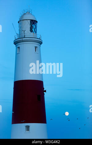 Portland Bill, Dorset, UK. 15 juillet, 2019. Près d'une pleine lune juste après le coucher du soleil avec la célèbre Portland Bill Lighthouse, Dorset, après une journée sans nuages sur la côte sud-ouest de la Grande-Bretagne. Peter Lopeman/Alamy Live News Banque D'Images