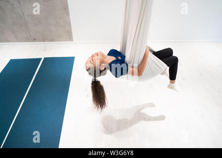 Portrait d'une belle jeune fille engagée dans fly yoga sur toiles. Banque D'Images