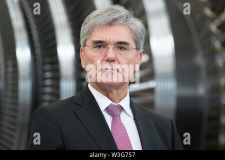 15 juillet 2019, Saxe, Görlitz : Après la signature d'un pacte de l'avenir dans un hall de production à l'usine Siemens à Görlitz, Siemens Chef Joe Kaeser se place en avant d'une turbine. Un mois et demi avant l'élections de l'état en Saxe, la chancelière Merkel visite l'usine Siemens à la Neisse ville de Görlitz et une réunion du réseau de femmes dans la capitale de l'état. Photo : Sebastian Kahnert/dpa-Zentralbild/dpa Banque D'Images