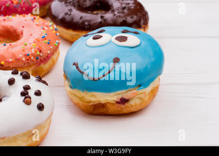 Beignet bleu drôle sur une table en bois. Banque D'Images