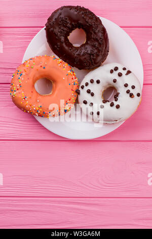 Assiette avec beignets sur fond de bois rose. Banque D'Images