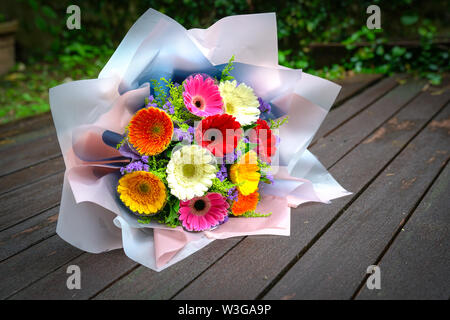 Main coloré bouquet de marguerites Gerbera fleurs Banque D'Images