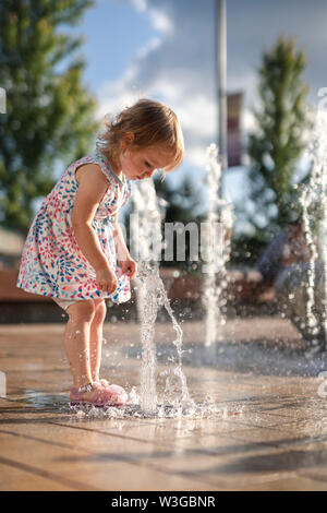 Habillé en costume enfant humide à un parc de la ville Banque D'Images