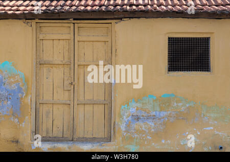 Tuile d'argile vieille maison de style Kerala avec peinture jaune vif et rustique aspect ancien prises dans les régions rurales de l'Inde. Banque D'Images