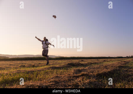 Backpacker traveler walking au lever et jeter hat dans le vent Banque D'Images