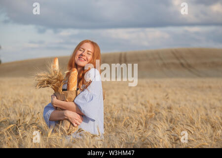 Ou agricultrice baker avec baguettes de seigle, champ de blé Banque D'Images