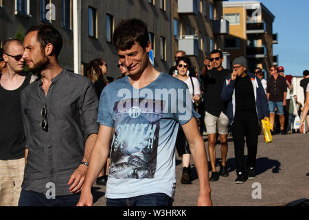 Les jeunes hommes flânant dans Josafatinkatu au soleil du soir au cours de Kallio Block Party 2017 à Helsinki, Finlande Banque D'Images