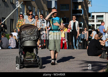 Jeune couple avec un bébé en flânant dans Josafatinkatu Kallio Block Party 2017 à Helsinki, Finlande Banque D'Images