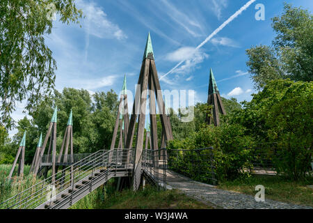 Pont piétonnier en bois architectural frappant sur une rivière dans un paysage naturel sauvage Banque D'Images