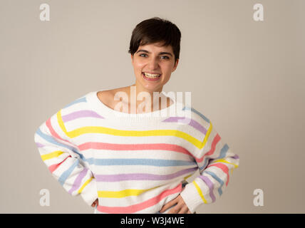 Portrait of happy and smiling young caucasian female rire et s'amuser à rayures multicolores sur fond neutre isolé de cavalier. Les gens, po Banque D'Images