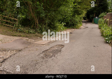 Problème de l'autoroute chassez pas vidange faire face aux inondations et érosion de l'eau de pluie flux indirects tarmac sur country lane créer hazard Banque D'Images