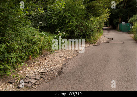 Problème de l'autoroute chassez pas vidange faire face aux inondations et érosion de l'eau de pluie flux indirects tarmac sur country lane créer hazard Banque D'Images