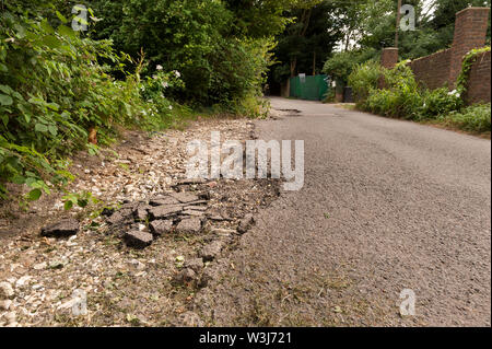 Problème de l'autoroute chassez pas vidange faire face aux inondations et érosion de l'eau de pluie flux indirects tarmac sur country lane créer hazard Banque D'Images