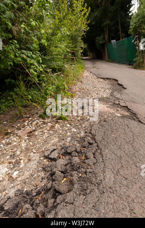 Problème de l'autoroute chassez pas vidange faire face aux inondations et érosion de l'eau de pluie flux indirects tarmac sur country lane créer hazard Banque D'Images