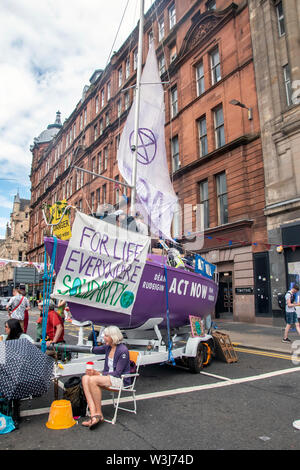 Glasgow, Ecosse, Royaume-Uni. 15 Juillet 2019 : Extinction rébellion bloquer l'une des routes principales dans le centre-ville de Glasgow avec un bateau. Banque D'Images