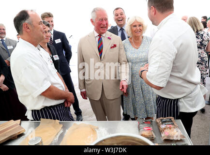 Le Prince de Galles et la duchesse de Cornouailles parler au personnel de l'avant d'une garden party pour célébrer le 50e anniversaire de Ginsters bakery à LOCRONAN, dans le cadre de leur visite à Cornwall. Banque D'Images