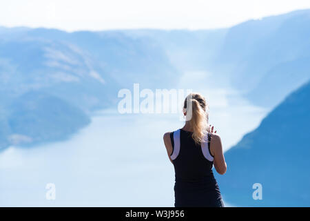 PULPIT ROCK, LA NORVÈGE - Juillet 26, 2018 : Unknown woman profiter de la superbe vue sur le Lysefjord de Pulpit Rock. L'Pulpit Rock ou Preache Banque D'Images