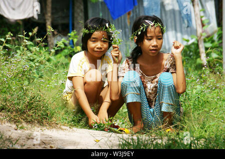 Deux jolies petites filles s'asseoir picking wild flower princess, couronne de tête faire à la couronne d'herbages en été, l'enfance de campagne si charmant, mignon Banque D'Images