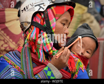 H'Mong vietnamienne hill-tribu femme en tenue tribale rss télévision riz nouilles à son joli petit garçon. Banque D'Images