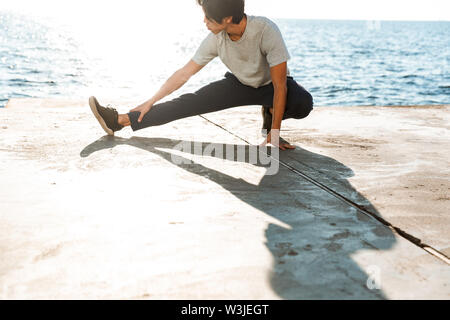 Fit confiance sportif asiatique vous exercez à l'extérieur au bord de la mer Banque D'Images