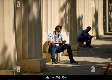 Londres, Royaume-Uni. 16 juillet 2019. UK - Les hommes se détendre au soleil sur le Mall près de St James's Park. Les températures sont appelées à progresser à 26C. Crédit : Stephen Chung / Alamy Live News Banque D'Images