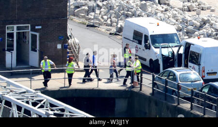 Les fonctionnaires de la force frontalière un processus soupçonné famille migrante de Dover, Kent, après qu'ils ont été recueillis à partir de petits bateaux dans le chenal, tôt le mardi matin. Banque D'Images