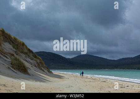 L'homme et de la femme marchant sur la plage de Luskentyre, Isle of Harris, Scotland Banque D'Images