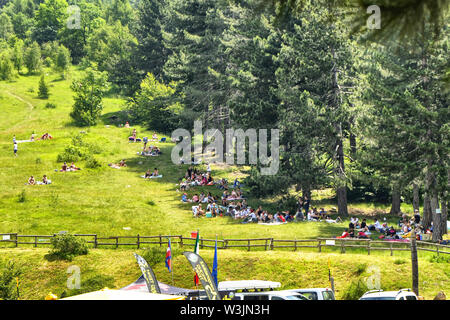 Col du Lys, Piémont, Italie. Juillet 2019. Les gens à la buvette de profiter de la pente de la montagne avec une grande pelouse verte à picni Banque D'Images