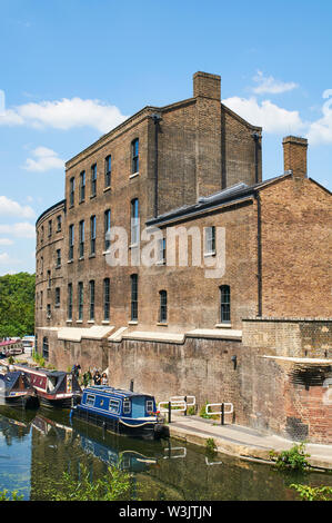 Le Regents Canal à Coal Gouttes Yard, Kings Cross, London UK, avec les poissons nouvellement convertis et bâtiment du charbon Banque D'Images