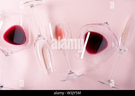 Assorted wineglasses de rouge, rose et vin blanc couché sur fond rose. Dégustation concept. Mise à plat. Vue d'en haut. Copy space Banque D'Images