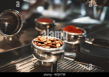 Deux titulaires de l'un café avec un autre café frais moulu avec haricots rôti debout sur machine à café close up Banque D'Images