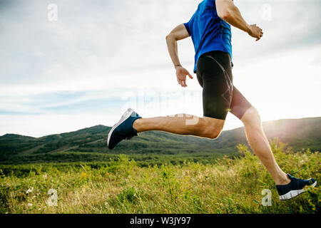 Coureur athlète courir sur plateau de montagne d'été dans le coucher du soleil Banque D'Images