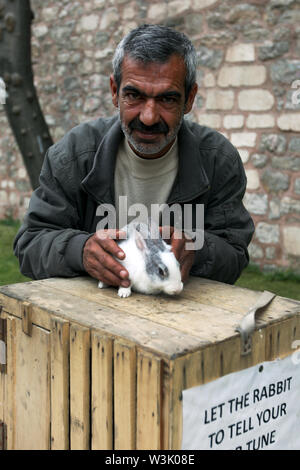 Un turc avec son lapin dire de fortune qui s'amuse les touristes, dans le quartier de Sultanahmet d'Istanbul en Turquie. Banque D'Images