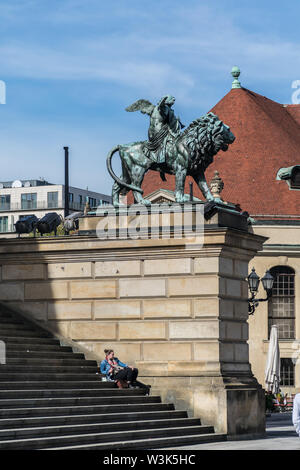 Berlin, Allemagne - 23 septembre 2018 : Statue d'un ange équitation un lion en face de Konzerthaus de Berlin avec une fille se reposant dans le starway outre Banque D'Images