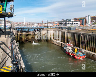 Barrage Tawe Lock à Swansea. Un petit bateau de pêche est dans la serrure que la serrure est rempli d'eau. Port de plaisance de Swansea, Pays de Galles, Royaume-Uni. Banque D'Images