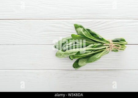 Vue de dessus les feuilles d'épinards vert sur la table en bois blanc Banque D'Images