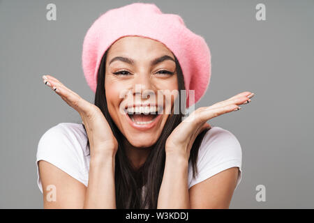 Gros plan Photo de jolie femme surprise en t-shirt de base et beret réjouissance et dresser des mains sur fond gris isolé Banque D'Images