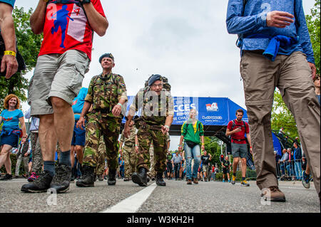 Un soldat passe la ligne d'arrivée tout en disant bonjour à la caméra au cours de la première journée.puisque c'est la plus grande épreuve de marche de plusieurs jours, les quatre jours le mois de mars est considéré comme le premier exemple d'esprit sportif et les liens entre militaires et civils et les femmes de nombreux pays différents. Les participants à la 103e a commencé les quatre jours de Nimègue, à l'Wadren à 4h, a traversé la Waalbrug (le légendaire pont de Nimègue), et ils ont adopté pour l'Elst (la ville de l'époque), où la couleur officielle était bleu. La journée était froide, avec des températures plus basses que les Banque D'Images