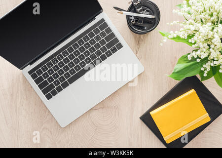 Vue de dessus de la papeterie, ordinateur portable et de blocs-notes sur la table en bois Banque D'Images