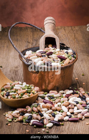 Soupe de légumineuses et céréales secs mélangés dans une marmite en cuivre sur table en bois rustique.still life Banque D'Images