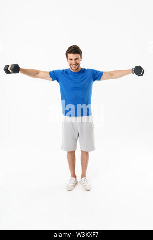Photo pleine longueur de happy sportsman en short et t-shirt lever des poids d'entraînement tout en faisant plus isolées sur fond blanc Banque D'Images
