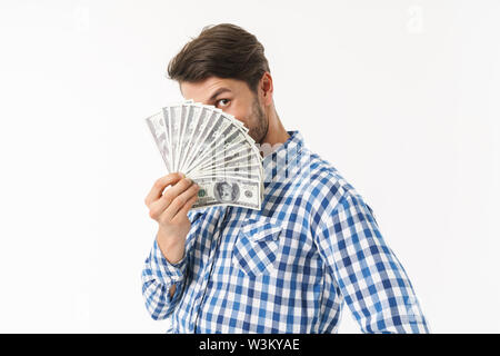 Photo de barbus émotionnelle unshaved man dressed in casual shirt posing isolated over white wall background de la détention de monnaie couvrant la face. Banque D'Images