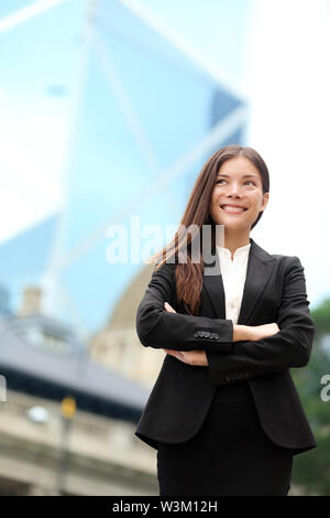 Asian business woman confiant piscine à Hong Kong article fiers en fonction de cross-armé dans le quartier d'affaires. Young mixed race asiatique chinois femelle / femelle caucasienne professionnel dans le centre de Hong Kong. Banque D'Images