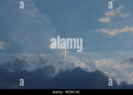 Sentier de l'avion venant de sombres nuages dans le ciel bleu Banque D'Images