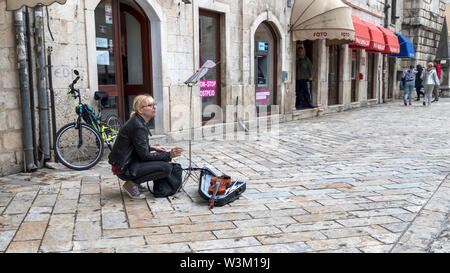 Le Monténégro, 30 avril 2019 : une femme violoniste et prendre une pause cigarette dans la vieille ville de Kotor Banque D'Images