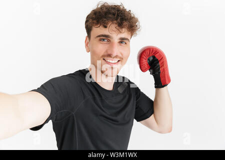 Gros plan de la photo de l'homme sportif brunette en t-shirt de sourire et de prendre en photo selfies gant de boxe isolated over white background Banque D'Images